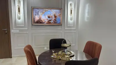 a dining room with a table and a painting on the wall at cozy appartement in Casablanca