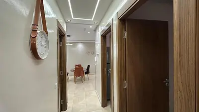 a hallway with a clock on the wall and a table at cozy appartement in Casablanca