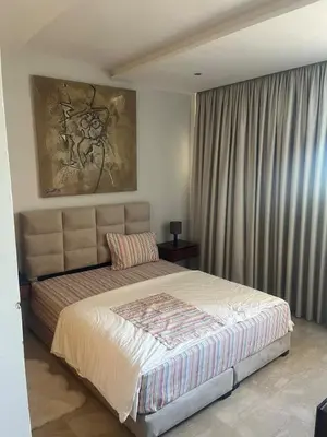 a bedroom with a bed and a painting on the wall at Evazion in O Ben Slimane