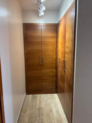 a walk in closet with wooden doors in a room at Cosy 2 chambres - Clim & Parking in Casablanca