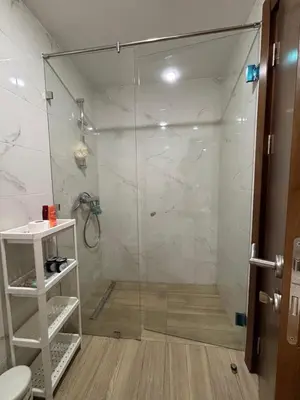 a shower with a glass door in a bathroom at Cosy 2 chambres - Clim & Parking in Casablanca