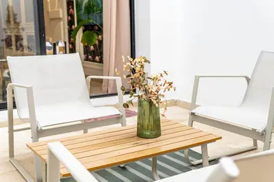 a vase of flowers on a table with two chairs at maarif Centre elegant et comfortable duplex in Casablanca
