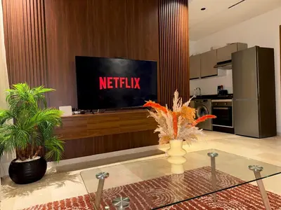 a living room with a television and a kitchen at Studio Élégant et Moderne a Maarif, Casablanca in Casablanca