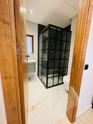 a bathroom with a toilet and a glass cabinet at Studio Élégant et Moderne a Maarif, Casablanca in Casablanca