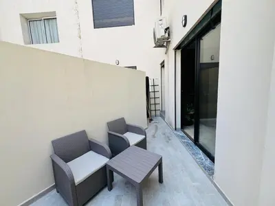 two chairs and a table next to a building at Studio Élégant et Moderne a Maarif, Casablanca in Casablanca