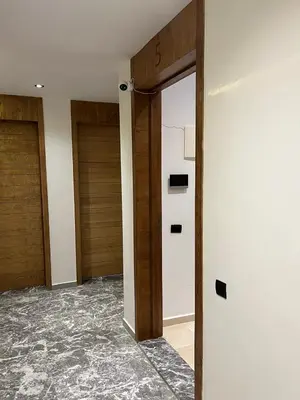 an empty hallway with two wooden doors in a building at Studio Élégant et Moderne a Maarif, Casablanca in Casablanca