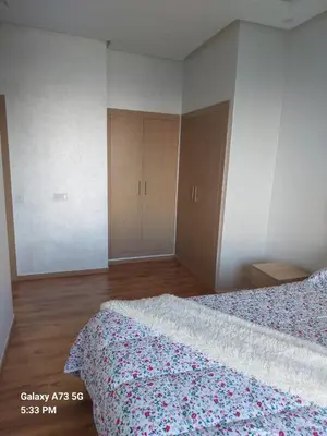 a bedroom with a bed with a floral bedspread at appartement à Zenata casablanca in Aïn Harrouda