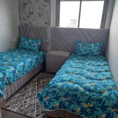 a small bedroom with a bed and a couch at appartement à Zenata casablanca in Aïn Harrouda