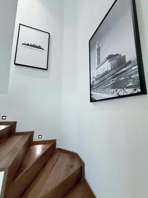 a television hanging on a wall next to stairs at Luxurious Boho-Styled Duplex - Rooftop Sky Pool in Casablanca