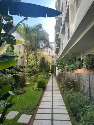 a walkway between two buildings with a blue umbrella at Modern Cozy Apartment Near beach in Casablanca
