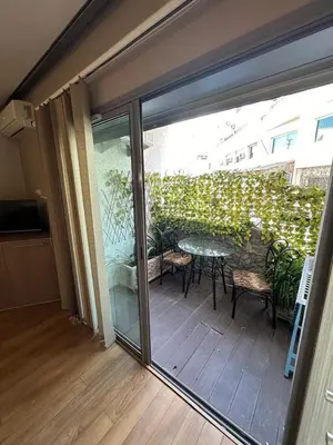 a sliding glass door leading to a patio with a table and chairs at Modern Cozy Apartment Near beach in Casablanca