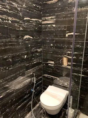 a black tiled bathroom with a toilet and a shower at Chic Studio Near Beach & Cafés in Casablanca
