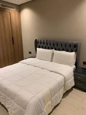 a bedroom with a large white bed with a black headboard at Chic Studio Near Beach & Cafés in Casablanca