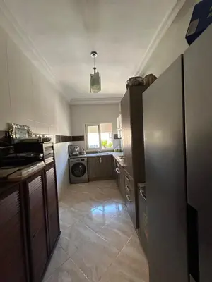 a small kitchen with a refrigerator and a sink at Ricoflores Palm in O Ben Slimane