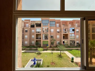 a window with a view of a large building at Ricoflores Palm in O Ben Slimane