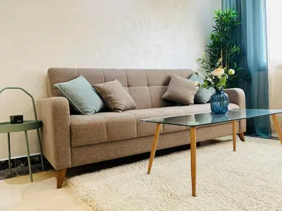 a living room with a couch and a glass table at Studio 1 Min Beach - Pool - Air conditioning - Fiber in Mohammedia