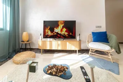a living room with a fire in a tv at Studio 1 Min Beach - Pool - Air conditioning - Fiber in Mohammedia