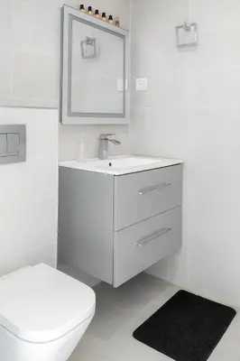 a white bathroom with a sink and a toilet at Kridarek - Bel appartement avec piscine à Dar Bouazza in Tamaris