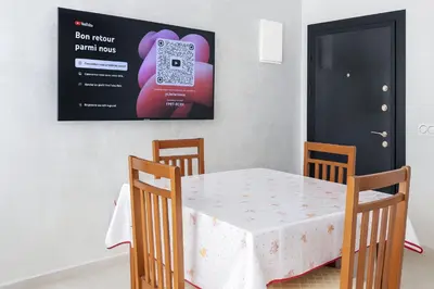 a dining room with a table with a phone on the wall at Kridarek - Bel appartement avec piscine à Dar Bouazza in Tamaris