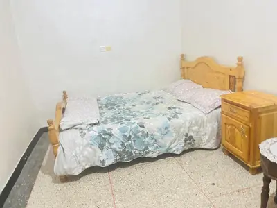 a bedroom with a bed and a wooden dresser at Msn in Rabat