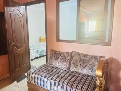 a room with a couch and a mirror and a bed at Msn in Rabat
