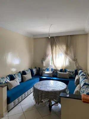 a living room with a blue couch and a table at Cozy apartment in Mohammedia in Mohammedia