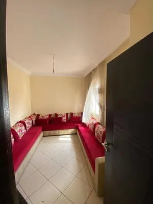 a red couch in a room with a window at Cozy apartment in Mohammedia in Mohammedia