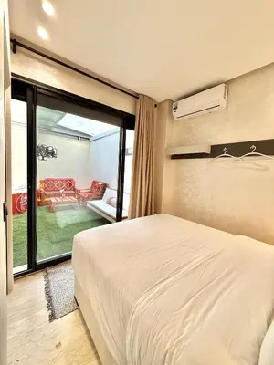 a bedroom with a bed and a sliding glass door at App Chic & Jacuzzi à Bourgogne près de la Corniche in Casablanca-Port