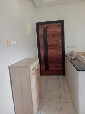 a kitchen with a wooden door and a counter at Appartement moderne et confortable proche plages in Casablanca