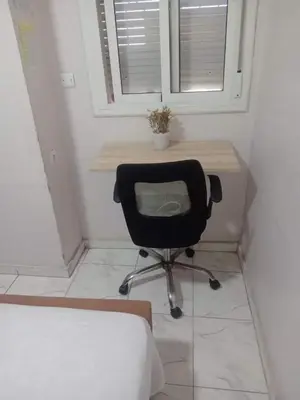a desk with a chair in a room with a window at Appartement moderne et confortable proche plages in Casablanca