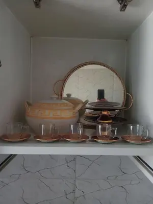 a shelf with dishes and a pot and a bowl at Appartement moderne et confortable proche plages in Casablanca
