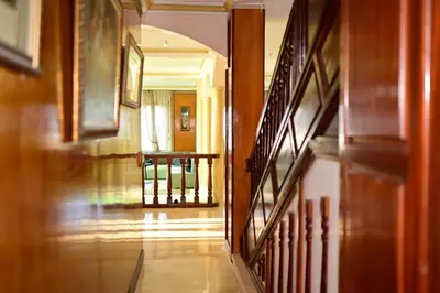 a hallway of a house with wooden floors and stairs at The 5-Suite Beachfront Villa in O Ben Slimane