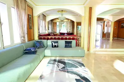 a living room with a blue couch and a bed at The 5-Suite Beachfront Villa in O Ben Slimane