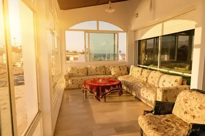 a living room with a couch and a table at The 5-Suite Beachfront Villa in O Ben Slimane
