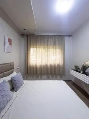 a white room with a bed and a window at Family Apartment à Jnane California Confort & Proximité in Casablanca