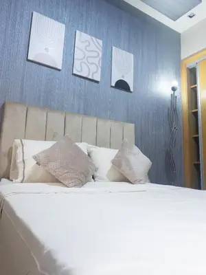 a bedroom with a bed with four pictures on the wall at Family Apartment à Jnane California Confort & Proximité in Casablanca