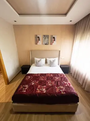a bedroom with a bed and two people taking pictures at Family Apartment à Jnane California Confort & Proximité in Casablanca