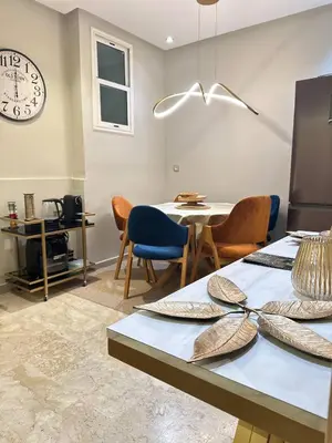 a dining room with a table and chairs and a clock at High Standing Duplex - Pool Sun in Mohammedia