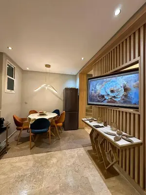 a dining room with a table and a large aquarium at High Standing Duplex - Pool Sun in Mohammedia