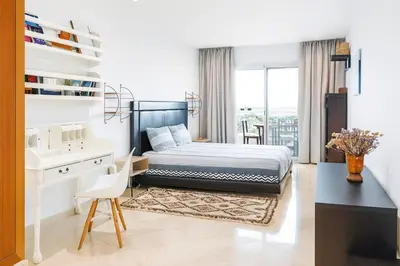a bedroom with a bed and a desk and a table at Kridarek - Charming apartment with pool in Tamaris in Tamaris