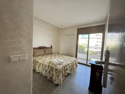 a bedroom with a bed with a table and a window at Appartement arome in Rabat