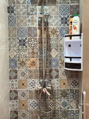a bathroom with a shower with tiles on the wall at Appartement arome in Rabat