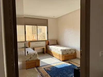a small room with two beds and a window at Appartement arome in Rabat