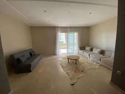 a living room with a couch and a coffee table at Appartement vue à la mer Bouznika in Sidi el Haj Bou Derbala