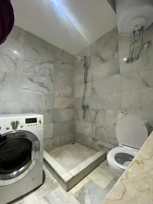 a bathroom with a washing machine and a toilet at Appartement vue à la mer Bouznika in Sidi el Haj Bou Derbala