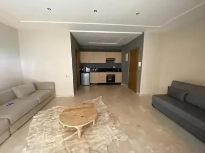 a living room with a couch and a coffee table at Appartement vue à la mer Bouznika in Sidi el Haj Bou Derbala