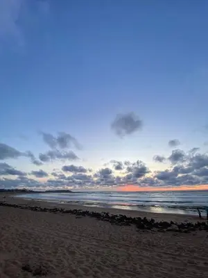 a beach with a cloudy sky and the ocean at Appartement vue à la mer Bouznika in Sidi el Haj Bou Derbala