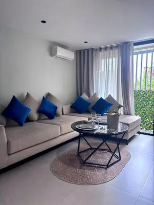 a living room with a couch and a table with blue pillows at Elegant Studio - Quiet & Stylish in Casablanca