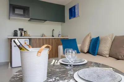 a table with plates and wine glasses and a couch at Elegant Studio - Quiet & Stylish in Casablanca