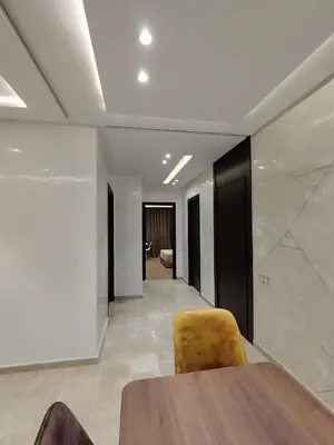 a dining room with a table and a yellow chair at Rosa Luxury Apartment , Confort, Vue Dégagée , Parking Privé près du CFC in Casablanca